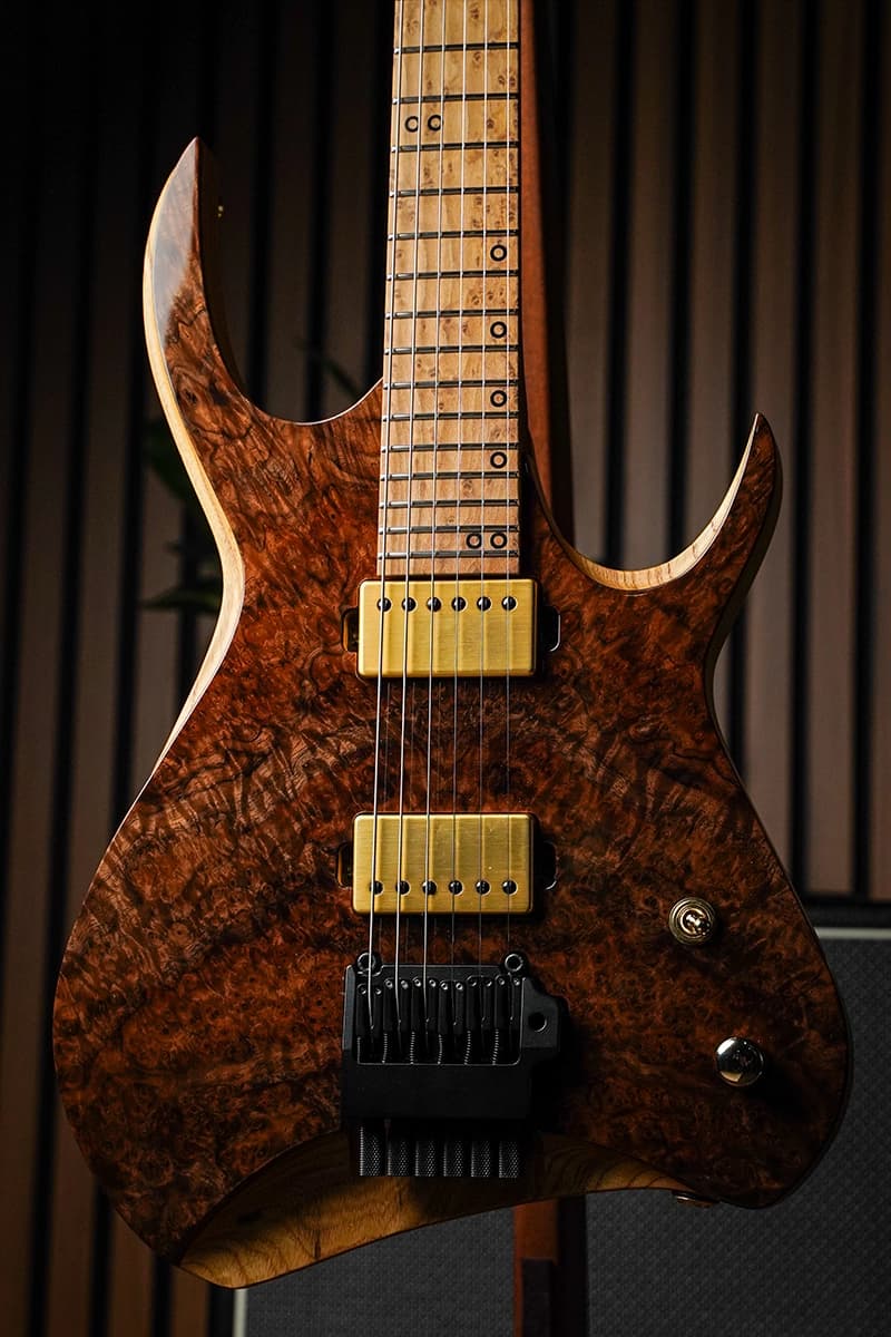 Kiesel Guitars Kyber Headless 6 string with figured claro walnut top, sculpted body edges, gold pickup covers, gold hardware, and roasted birdseye maple fingerboard
